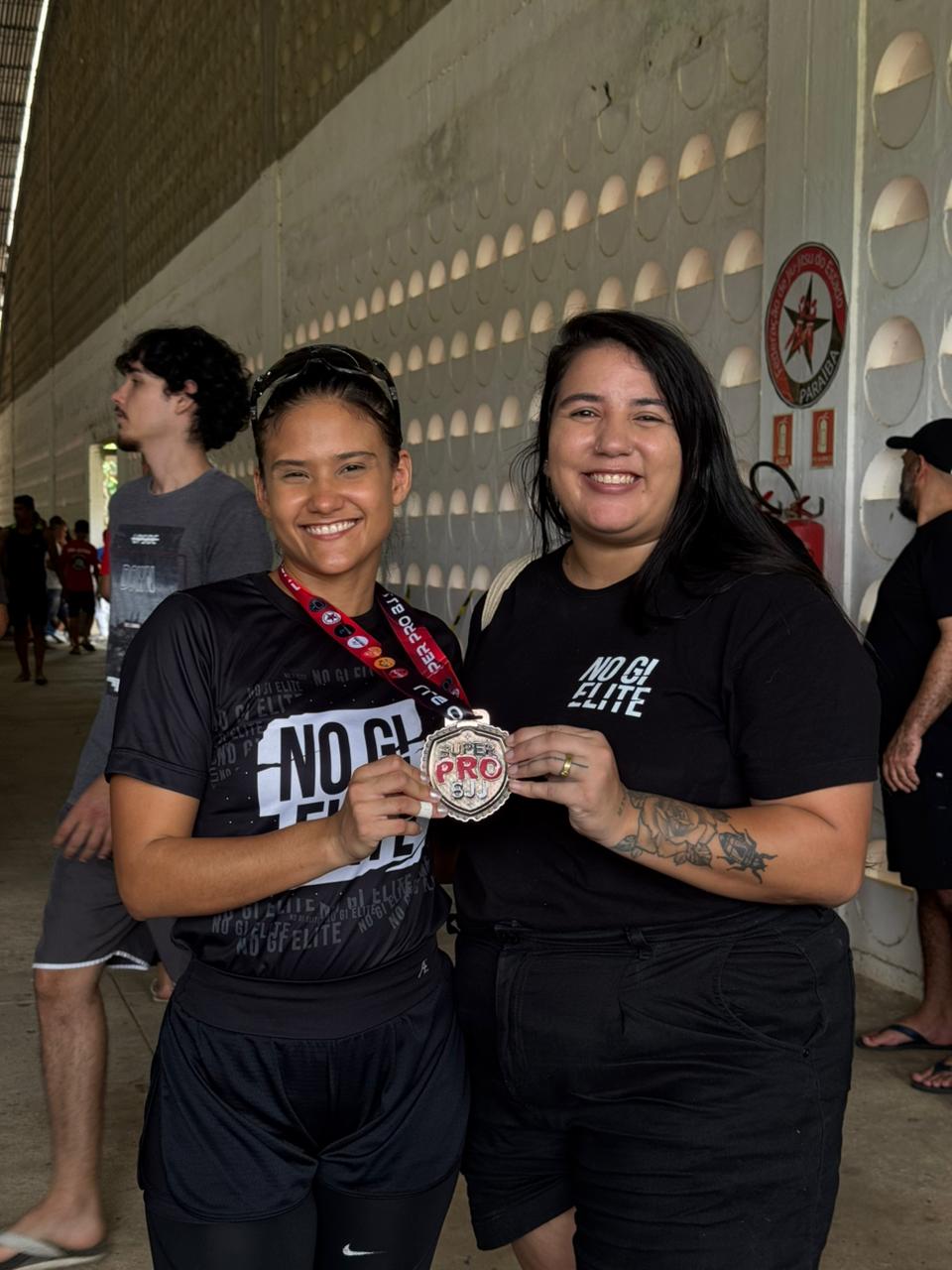 Atleta e integrante do CT exibindo uma medalha em competição